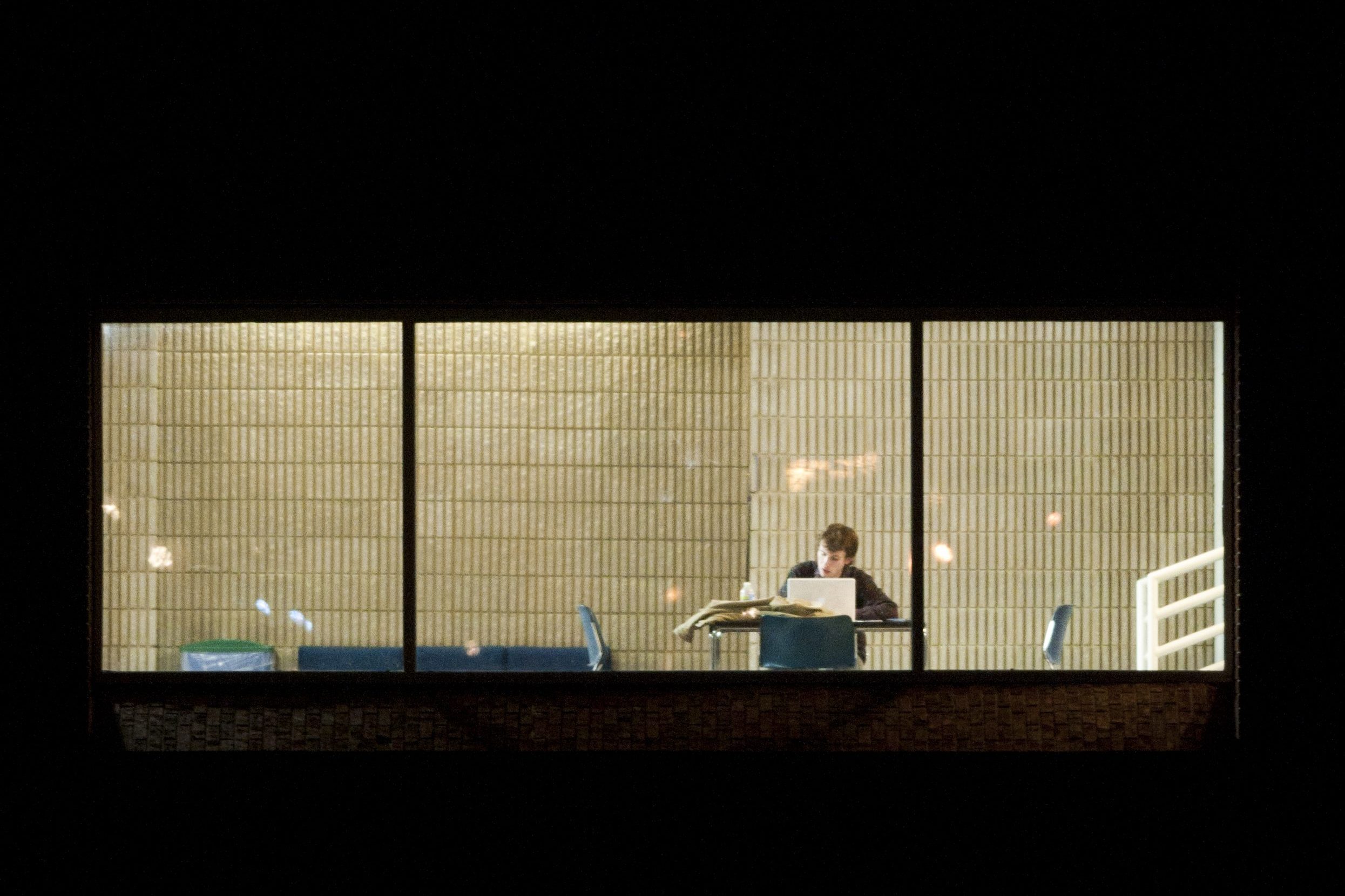 A student studies on second floor of UNCG's Health and Human Performance Building on the evening